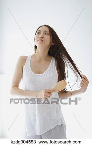 Young attractive Japanese woman doing her hair in the bathroom View Large Photo Image Stock Image - Young attractive Japanese woman doing her hair in the bathroom. Fotosearch
