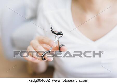 Stock Image - Young attractive Japanese woman doing her make-up at home. Fotosearch