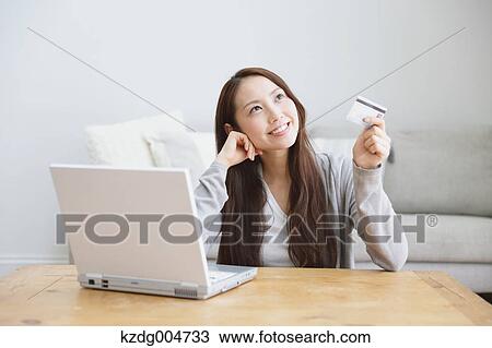 Young attractive Japanese woman doing online shopping at home View Large Photo Image Stock Image - Young attractive Japanese woman doing online shopping at home. Fotosearch