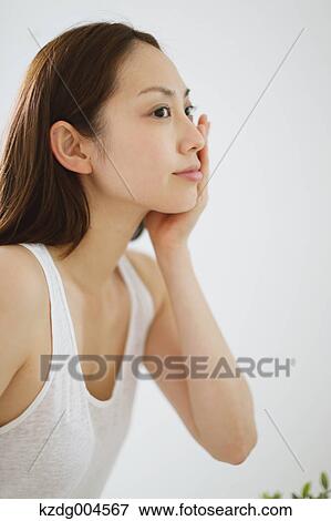 Young attractive Japanese woman doing skin care in the bathroom View Large Photo Image Stock Photo - Young attractive Japanese woman doing skin care in the bathroom. Fotosearch
