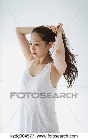 Young attractive Japanese woman doing her hair in the bathroom View Large Photo Image Stock Photo - Young attractive Japanese woman doing her hair in the bathroom. Fotosearch