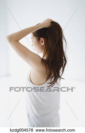 Young attractive Japanese woman doing her hair in the bathroom View Large Photo Image Stock Photo - Young attractive Japanese woman doing her hair in the bathroom. Fotosearch