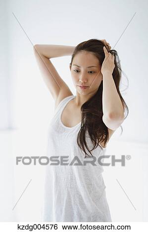 Young attractive Japanese woman doing her hair in the bathroom View Large Photo Image Stock Photograph - Young attractive Japanese woman doing her hair in the bathroom. Fotosearch