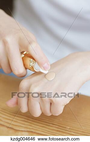 Stock Photograph - Young attractive Japanese woman doing her make-up at home. Fotosearch
