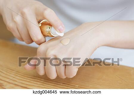 Stock Photography - Young attractive Japanese woman doing her make-up at home. Fotosearch
