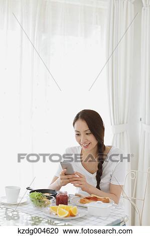 Young attractive Japanese woman having breakfast at home View Large Photo Image Stock Image - Young attractive Japanese woman having breakfast at home. Fotosearch