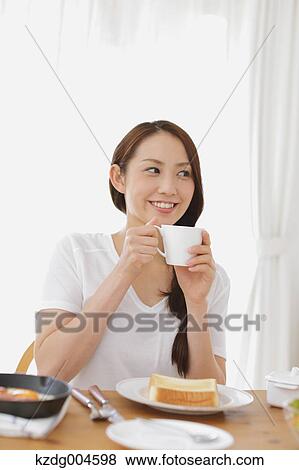 Young attractive Japanese woman having breakfast at home View Large Photo Image Stock Photo - Young attractive Japanese woman having breakfast at home. Fotosearch