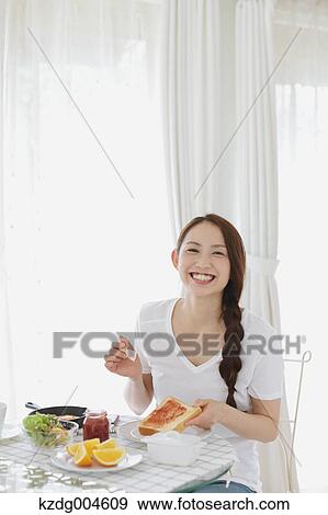 Young attractive Japanese woman having breakfast at home View Large Photo Image Stock Photo - Young attractive Japanese woman having breakfast at home. Fotosearch