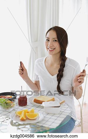 Young attractive Japanese woman having breakfast at home View Large Photo Image Stock Photograph - Young attractive Japanese woman having breakfast at home. Fotosearch