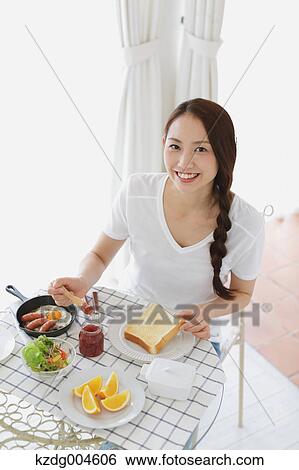 Young attractive Japanese woman having breakfast at home View Large Photo Image Stock Photograph - Young attractive Japanese woman having breakfast at home. Fotosearch