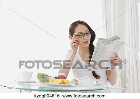 Stock Photograph - Young attractive Japanese woman having breakfast at home. Fotosearch