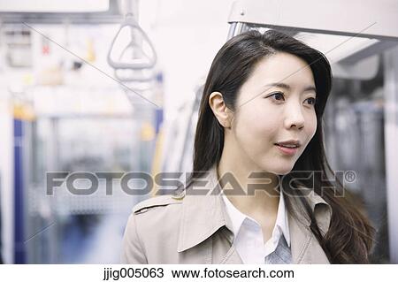 Stock Image - Young attractive Japanese woman on the train. Fotosearch