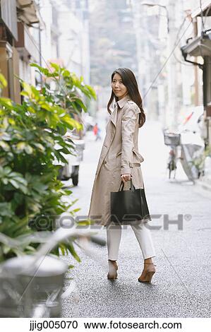 Stock Image - Young attractive Japanese woman downtown Tokyo. Fotosearch