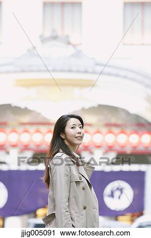 Stock Image - Young attractive Japanese woman downtown Tokyo. Fotosearch