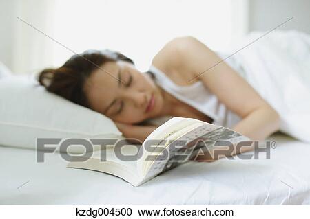 Stock Image - Young attractive Japanese woman sleeping in bed. Fotosearch