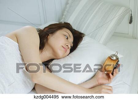Stock Photography - Young attractive Japanese woman sleeping in bed. Fotosearch