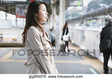 Stock Photograph - Young attractive Japanese woman waiting for the train. Fotosearch