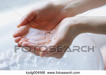 Stock Photograph - Young attractive Japanese woman washing face in the bathroom. Fotosearch