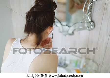 Stock Photography - Young attractive Japanese woman washing face in the bathroom. Fotosearch