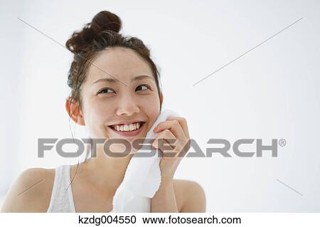 Young attractive Japanese woman wiping face with towel in the bathroom View Large Photo Image Stock Image - Young attractive Japanese woman wiping face with towel in the bathroom. Fotosearch