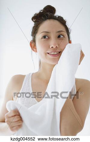 Young attractive Japanese woman wiping face with towel in the bathroom View Large Photo Image Stock Image - Young attractive Japanese woman wiping face with towel in the bathroom. Fotosearch