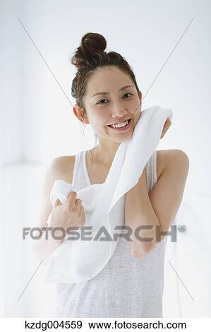 Young attractive Japanese woman wiping face with towel in the bathroom View Large Photo Image Stock Photo - Young attractive Japanese woman wiping face with towel in the bathroom. Fotosearch