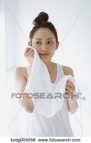 Young attractive Japanese woman wiping face with towel in the bathroom View Large Photo Image Stock Photograph - Young attractive Japanese woman wiping face with towel in the bathroom. Fotosearch