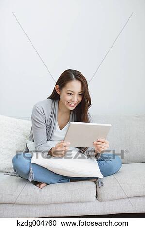 Young attractive Japanese woman with tablet on the sofa View Large Photo Image Stock Image - Young attractive Japanese woman with tablet on the sofa. Fotosearch