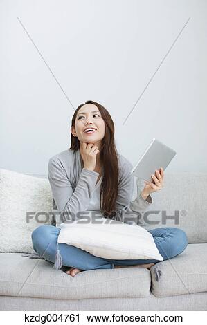 Young attractive Japanese woman with tablet on the sofa View Large Photo Image Stock Image - Young attractive Japanese woman with tablet on the sofa. Fotosearch