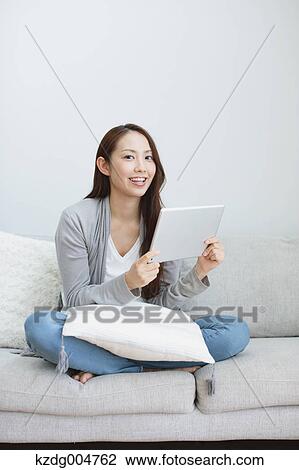 Young attractive Japanese woman with tablet on the sofa View Large Photo Image Stock Image - Young attractive Japanese woman with tablet on the sofa. Fotosearch