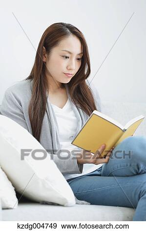 Young attractive Japanese woman with book on the sofa View Large Photo Image Stock Photo - Young attractive Japanese woman with book on the sofa. Fotosearch