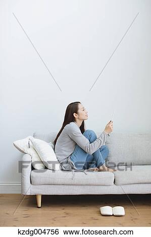 Young attractive Japanese woman with tablet on the sofa View Large Photo Image Stock Photograph - Young attractive Japanese woman with tablet on the sofa. Fotosearch