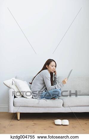 Young attractive Japanese woman with tablet on the sofa View Large Photo Image Stock Photography - Young attractive Japanese woman with tablet on the sofa. Fotosearch