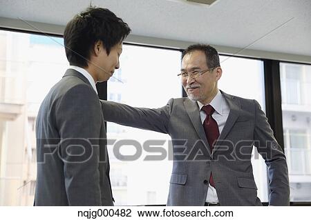 Young Japanese businessman being praised by his boss View Large Photo Image Stock Image - Young Japanese businessman being praised by his boss. Fotosearch