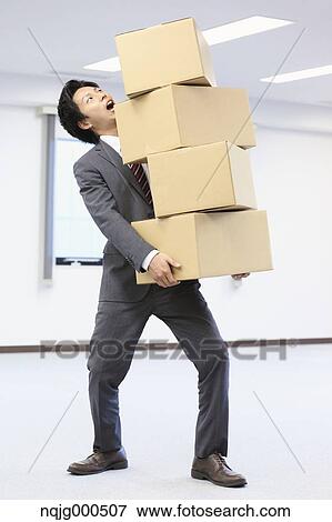 Young Japanese businessman carrying boxes View Large Photo Image Stock Photo - Young Japanese businessman carrying boxes. Fotosearch