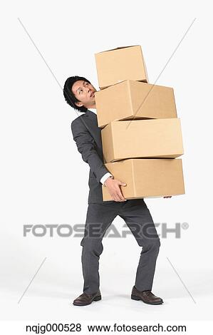 Young Japanese businessman carrying boxes View Large Photo Image Stock Photo - Young Japanese businessman carrying boxes. Fotosearch