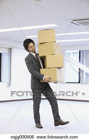 Young Japanese businessman carrying boxes View Large Photo Image Stock Photograph - Young Japanese businessman carrying boxes. Fotosearch