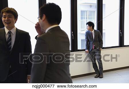 Young Japanese businessman looking out of office window View Large Photo Image Stock Photo - Young Japanese businessman looking out of office window. Fotosearch