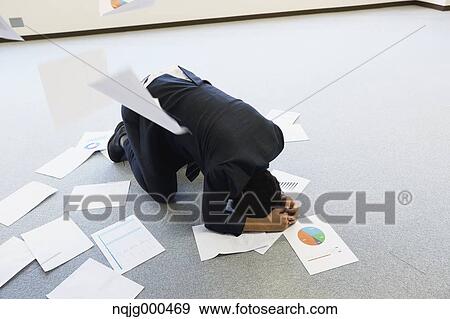 Stock Photo - Young Japanese businessman with lots of scattered documents. Fotosearch