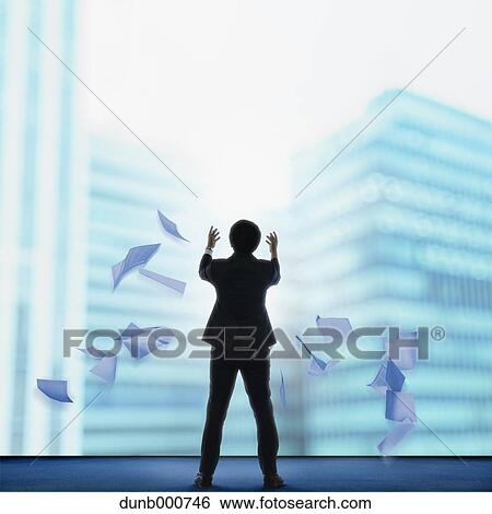 Stock Photograph - Young Japanese businessman with lots of scattered documents. Fotosearch