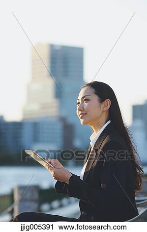 Young Japanese businesswoman with tablet by a river downtown Tokyo View Large Photo Image Stock Image - Young Japanese businesswoman with tablet by a river downtown Tokyo. Fotosearch