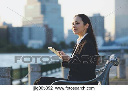 Young Japanese businesswoman with tablet by a river downtown Tokyo View Large Photo Image Stock Image - Young Japanese businesswoman with tablet by a river downtown Tokyo. Fotosearch