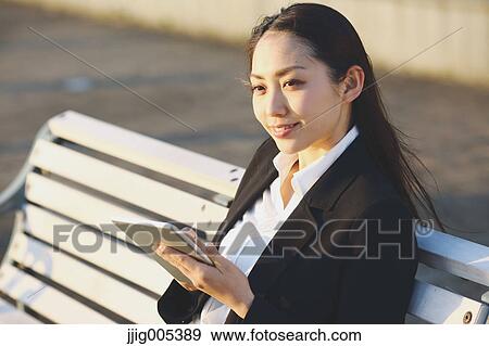 Young Japanese businesswoman with tablet by a river downtown Tokyo View Large Photo Image Stock Photo - Young Japanese businesswoman with tablet by a river downtown Tokyo. Fotosearch