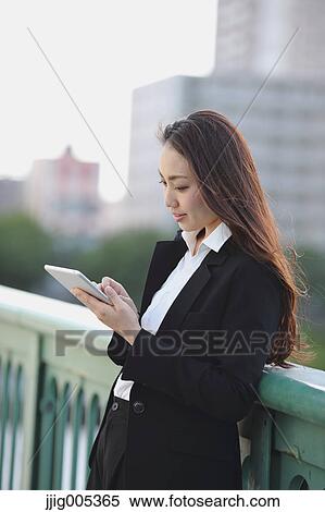 Young Japanese businesswoman with tablet by a river downtown Tokyo View Large Photo Image Stock Photography - Young Japanese businesswoman with tablet by a river downtown Tokyo. Fotosearch