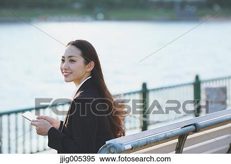 Young Japanese businesswoman with tablet by a river downtown Tokyo View Large Photo Image Stock Photography - Young Japanese businesswoman with tablet by a river downtown Tokyo. Fotosearch