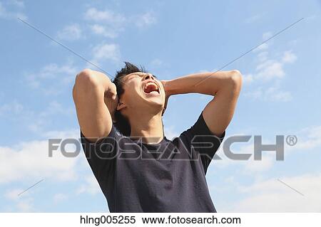 Young Japanese man cheering against blue sky View Large Photo Image Stock Photography - Young Japanese man cheering against blue sky. Fotosearch