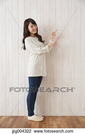 Young Japanese woman against wooden wall View Large Photo Image Stock Image - Young Japanese woman against wooden wall. Fotosearch