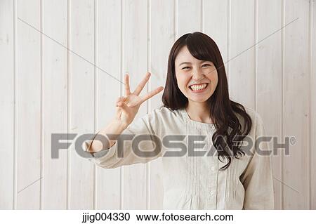 Young Japanese woman against wooden wall View Large Photo Image Stock Image - Young Japanese woman against wooden wall. Fotosearch