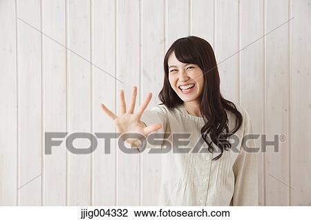 Young Japanese woman against wooden wall View Large Photo Image Stock Image - Young Japanese woman against wooden wall. Fotosearch