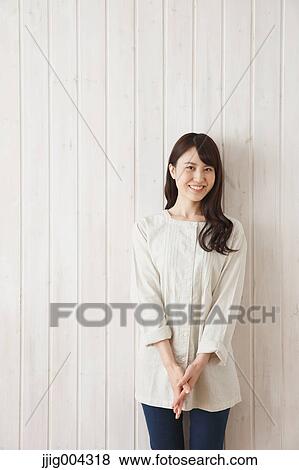 Young Japanese woman against wooden wall View Large Photo Image Stock Photo - Young Japanese woman against wooden wall. Fotosearch